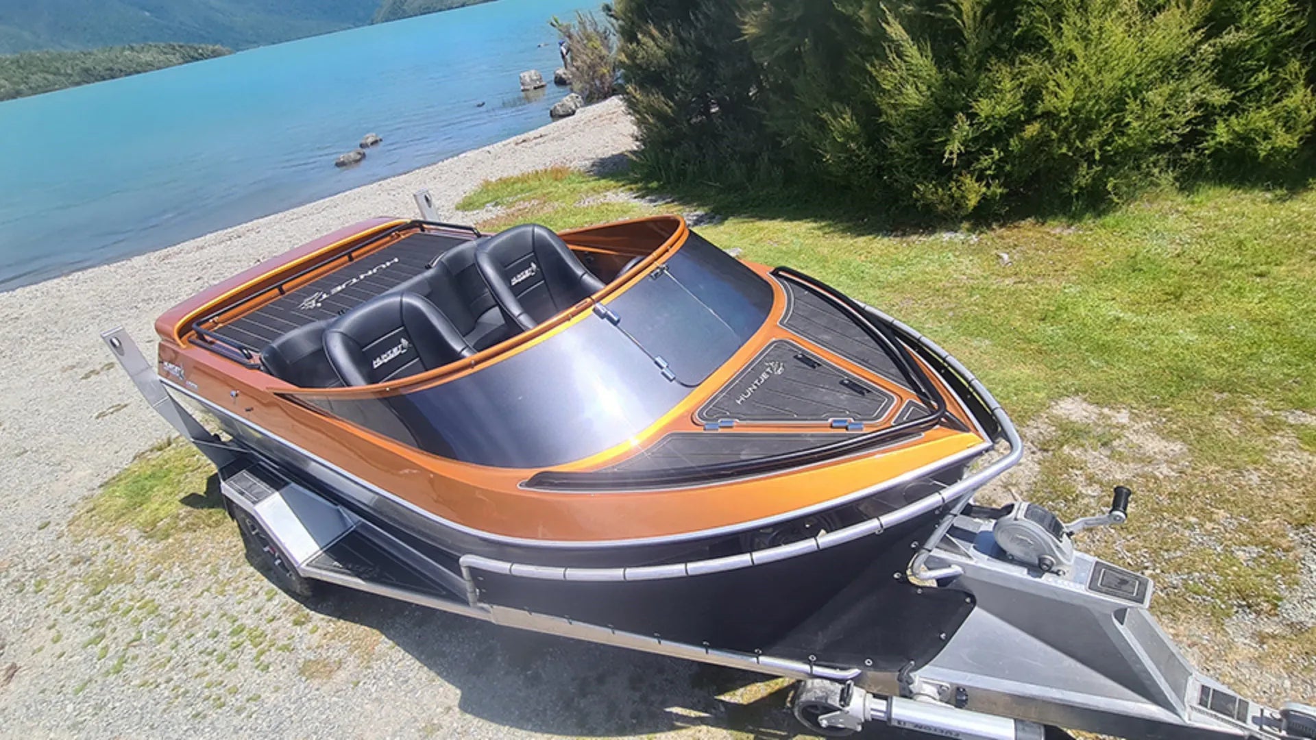 Orange and black bass boat with EVA foam flooring on shore